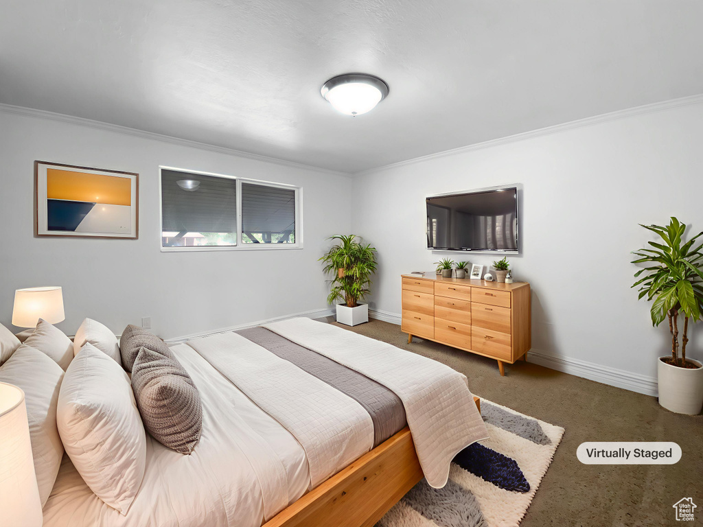Carpeted bedroom with crown molding and baseboards