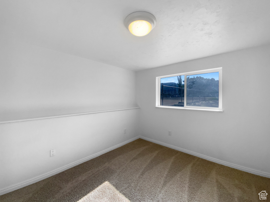 Empty room featuring carpet floors and baseboards