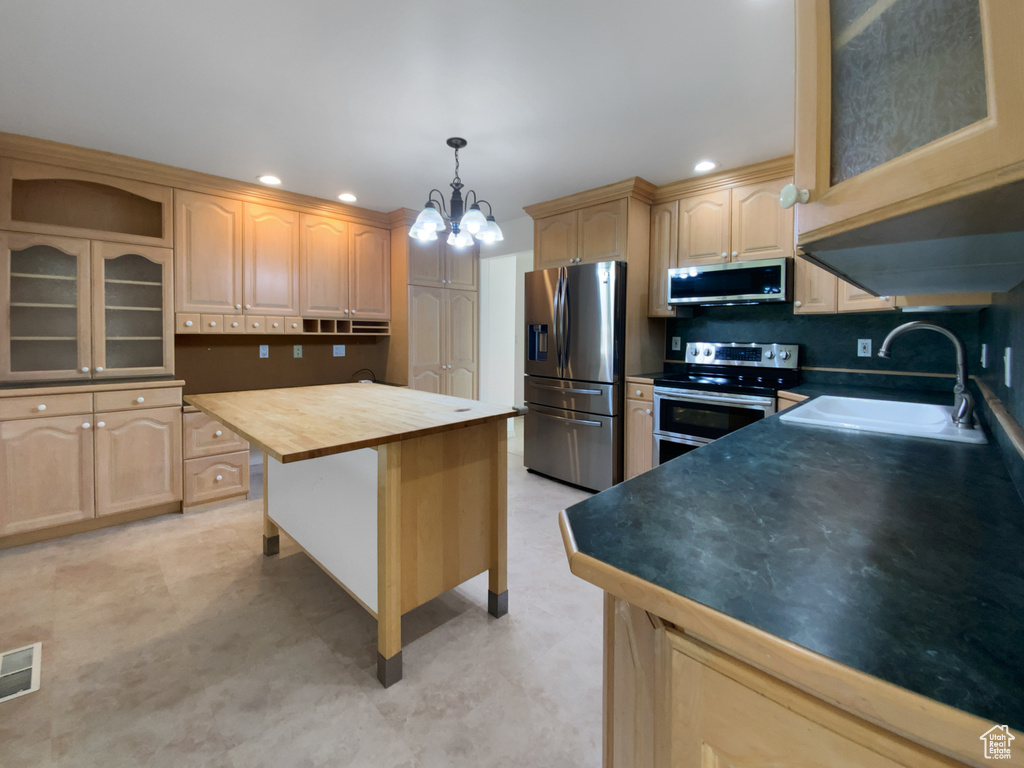 Kitchen featuring appliances with stainless steel finishes, light brown cabinetry, a chandelier, wooden counters, and recessed lighting