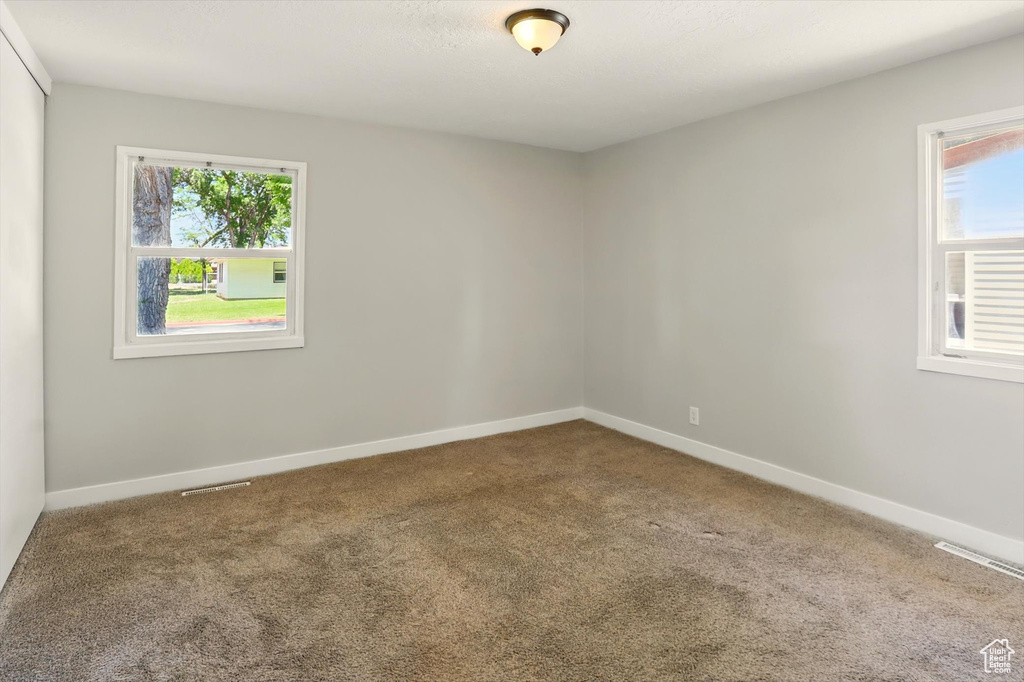 Carpeted spare room with healthy amount of natural light