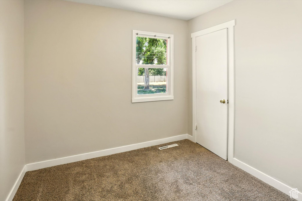 Carpeted empty room with baseboards
