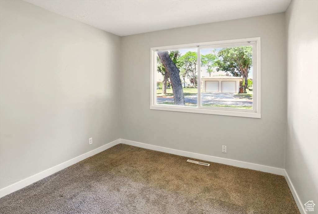 Empty room with dark carpet and baseboards
