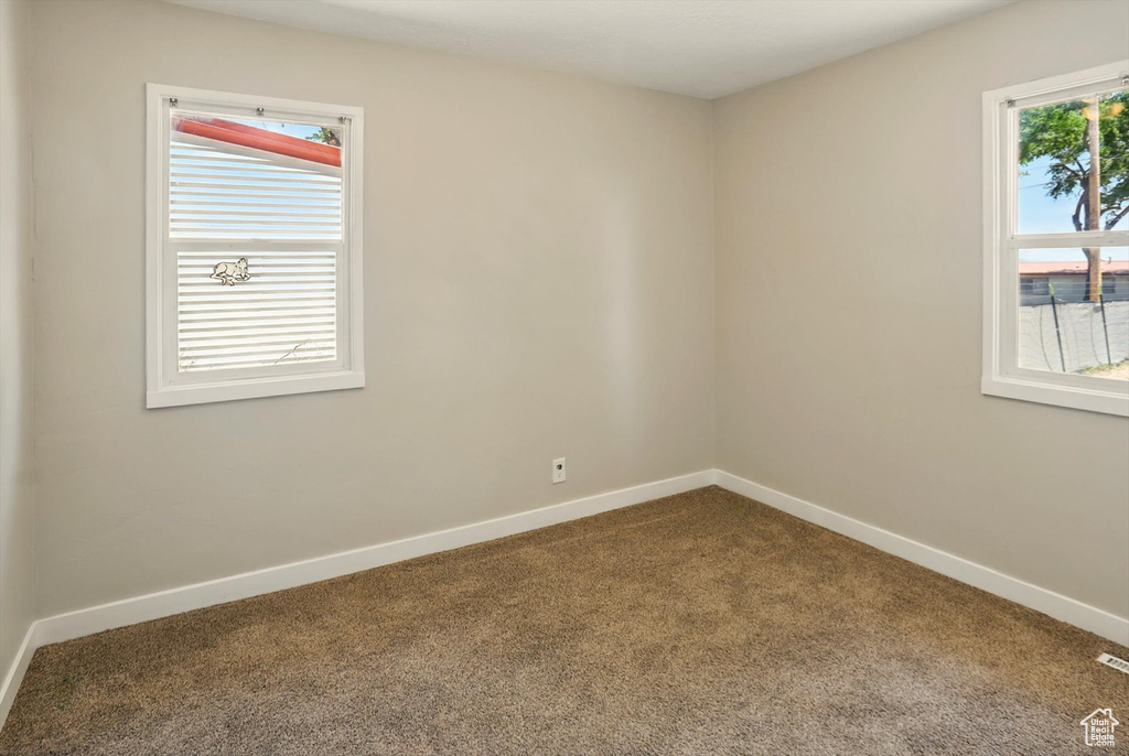 Spare room featuring carpet floors and baseboards