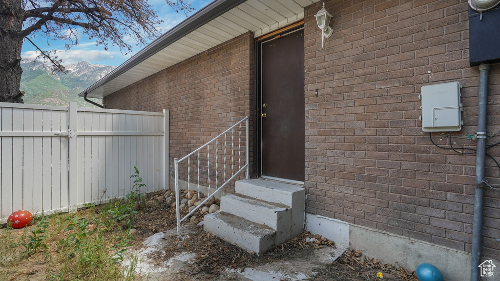 Doorway to property with brick siding and a mountain view