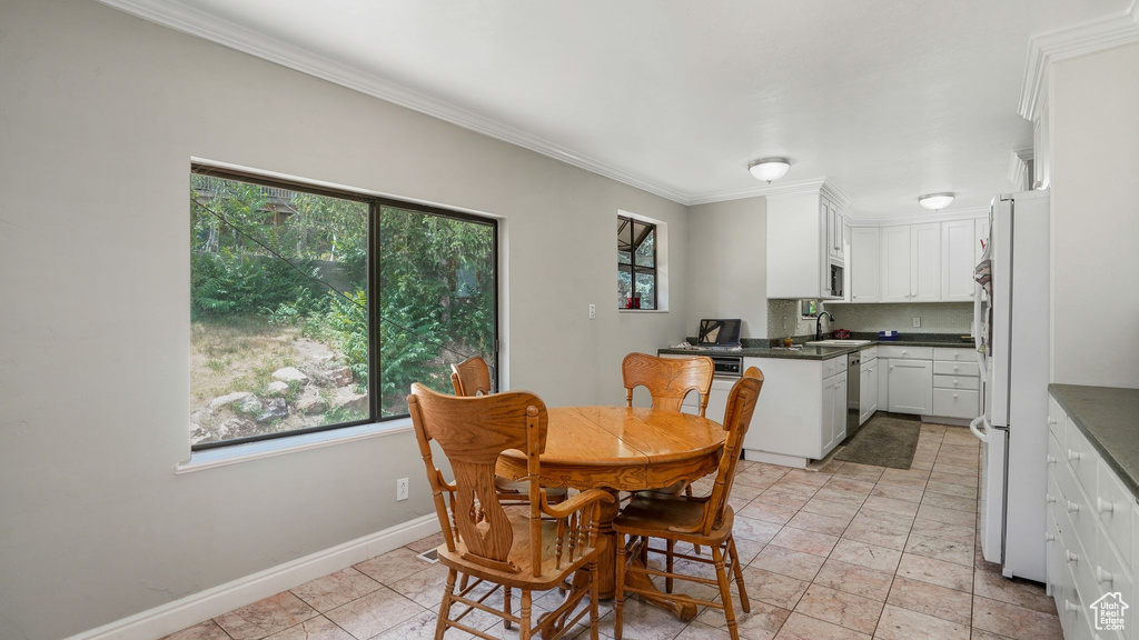 Dining space with healthy amount of natural light and crown molding