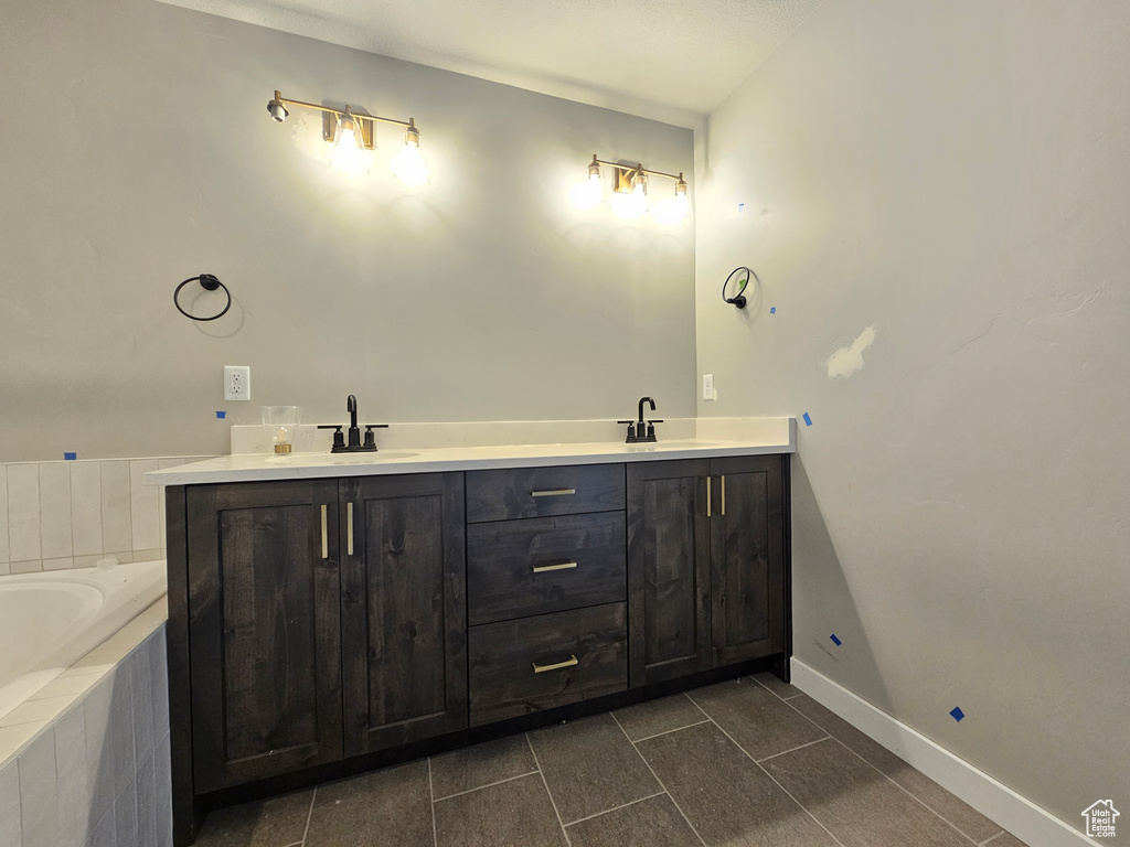 Bathroom featuring double vanity, a bath, and tile patterned flooring