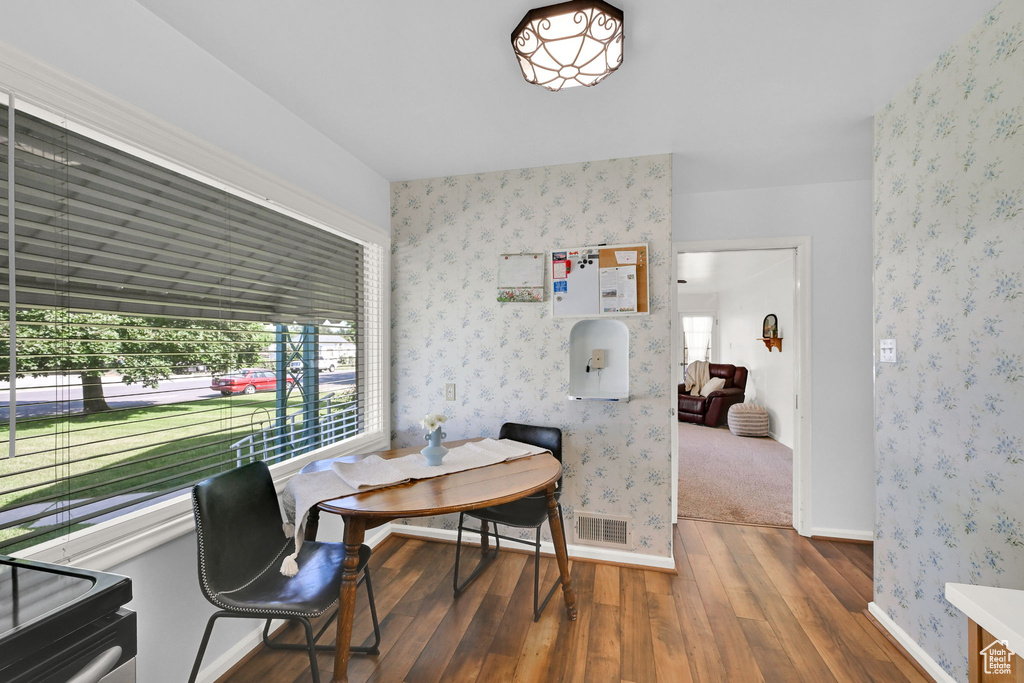 Dining room featuring hardwood / wood-style floors, plenty of natural light, and wallpapered walls