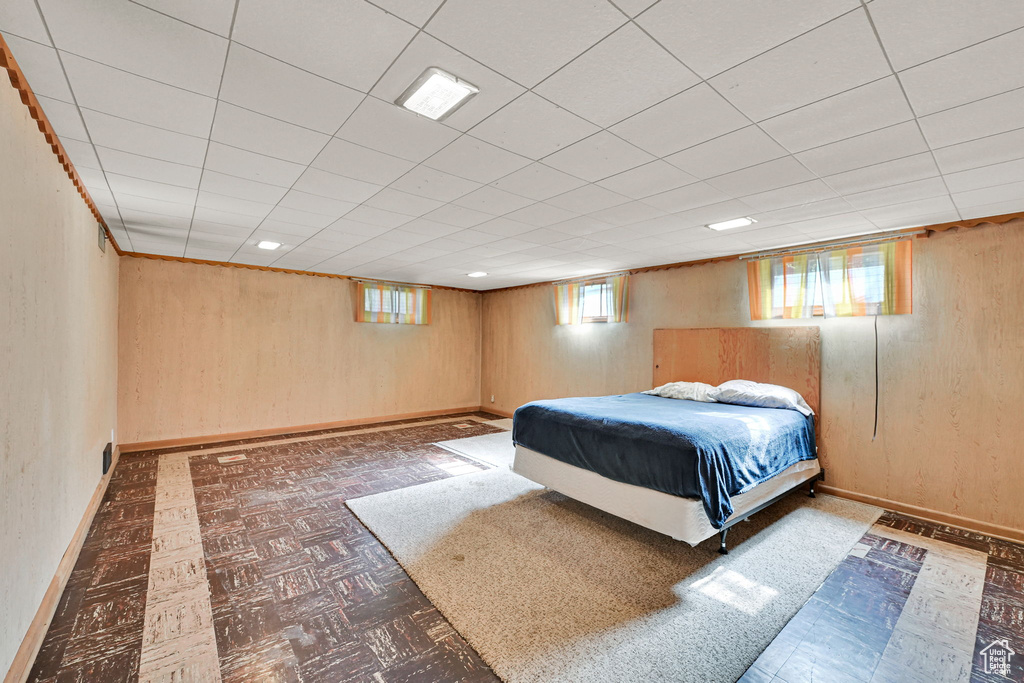 Bedroom with baseboards and wooden walls