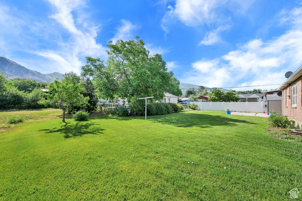 Fenced backyard featuring a mountain view