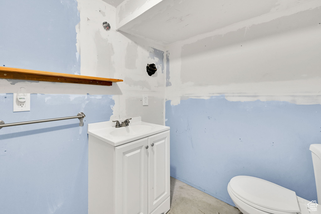Half bath with vanity and concrete floors