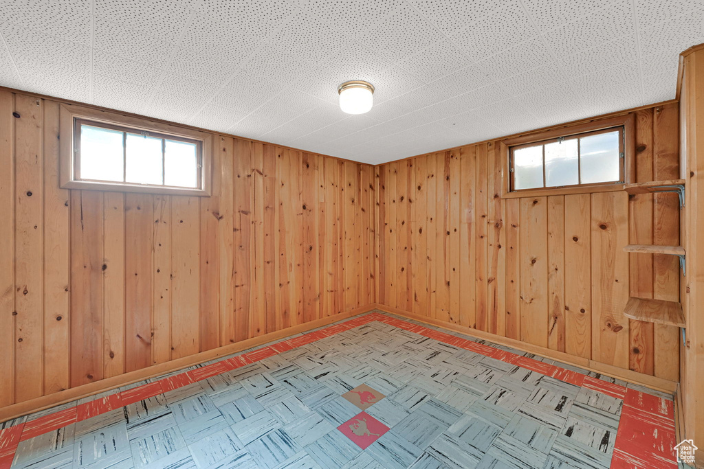 Basement featuring wood walls and baseboards