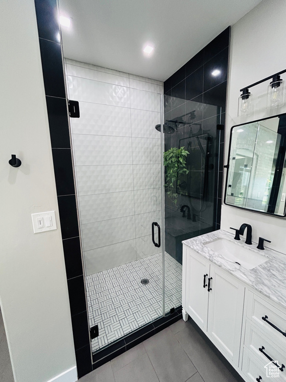 Full bath with vanity, tile patterned flooring, and a stall shower