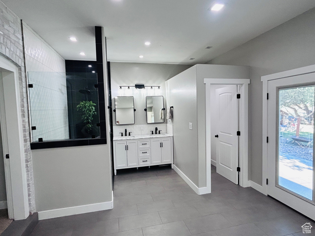 Bathroom with double vanity, a walk in shower, recessed lighting, plenty of natural light, and tile patterned flooring