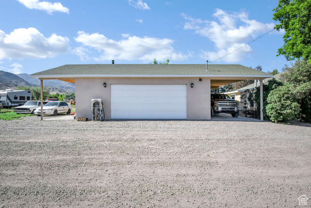Garage with a mountain view and gravel driveway