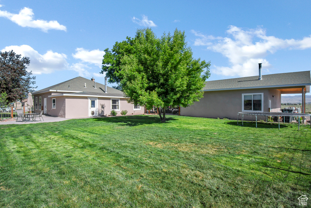 View of green lawn with a patio area