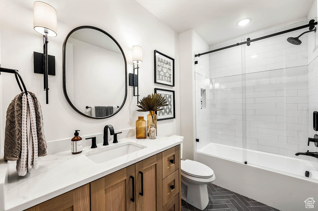 Bathroom featuring vanity and shower / bath combination with glass door