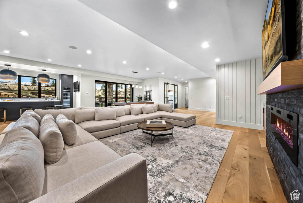 Living area with light wood-style floors, recessed lighting, and a glass covered fireplace