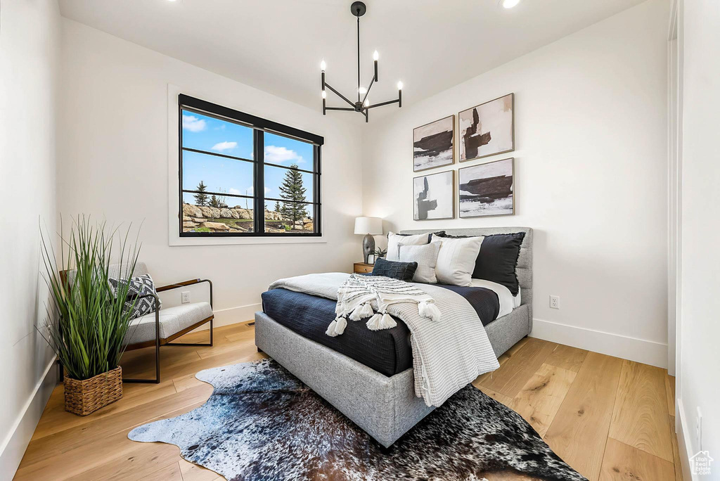 Bedroom with a chandelier, wood finished floors, and recessed lighting