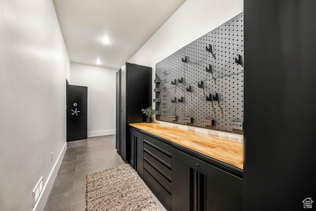 Bar featuring recessed lighting, tile patterned floors, and a workshop area