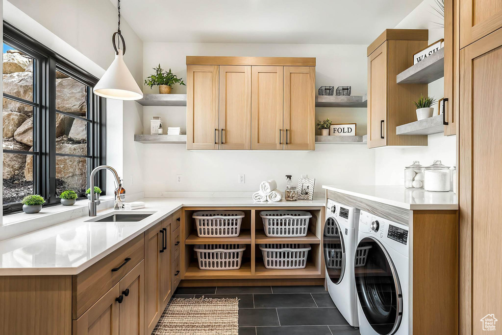 Laundry area featuring washer and dryer, cabinet space, and dark tile patterned floors
