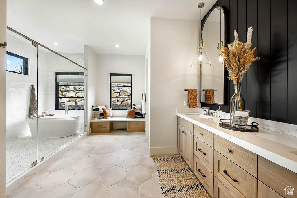Bathroom with a freestanding bath, vanity, healthy amount of natural light, tile patterned flooring, and recessed lighting