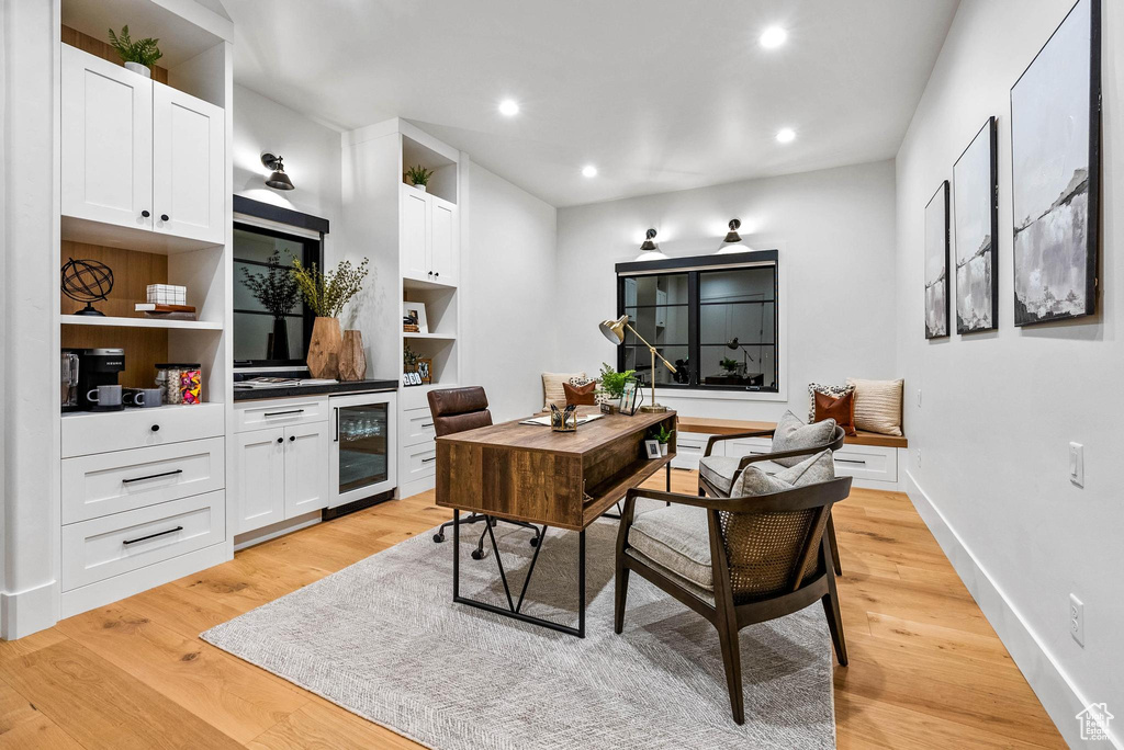 Office with wine cooler, light wood-style flooring, and recessed lighting