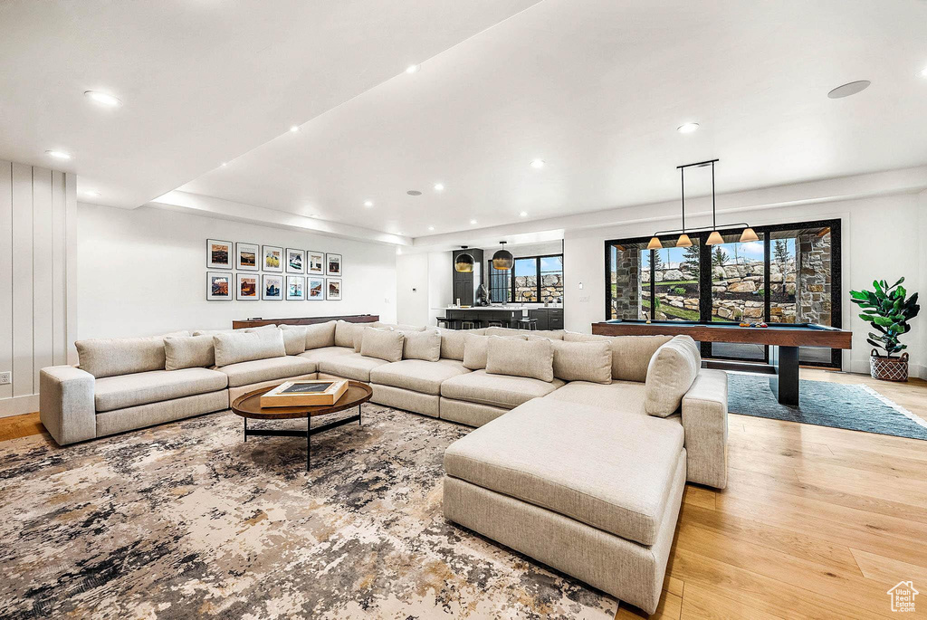 Living room with recessed lighting, light wood-style flooring, pool table, and bar