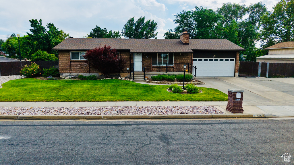Ranch-style home featuring brick siding, a garage, a chimney, driveway, and a shingled roof