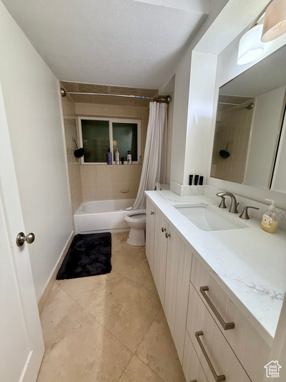 Full bath with shower / tub combo, vanity, and a textured ceiling