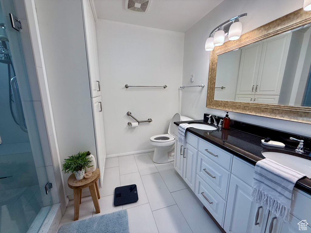 Full bathroom with double vanity, a stall shower, and tile patterned flooring