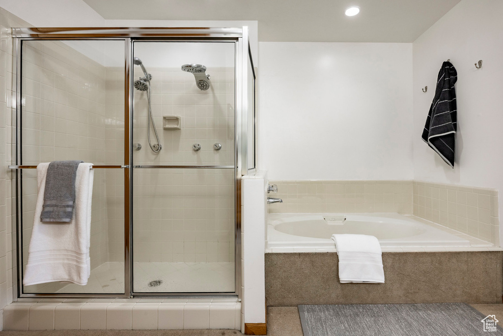 Bathroom with a shower stall, a bath, and recessed lighting