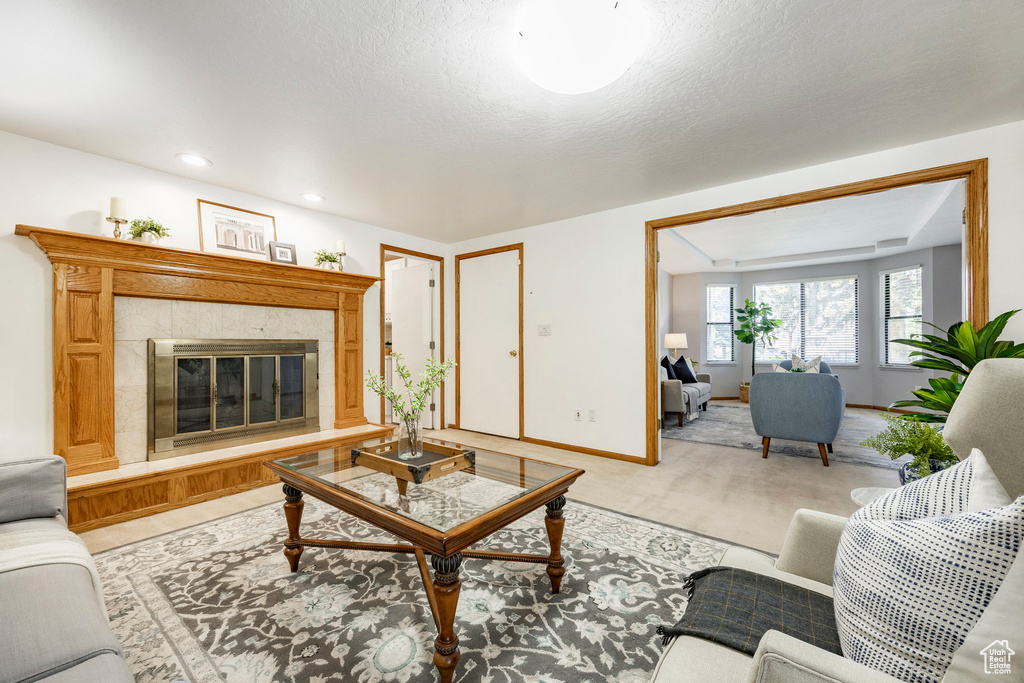 Living room featuring a premium fireplace, baseboards, and recessed lighting