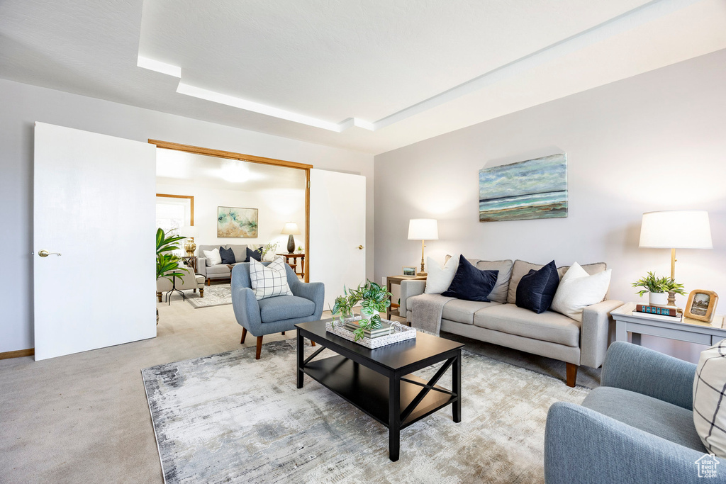 Living area with light carpet and a raised ceiling