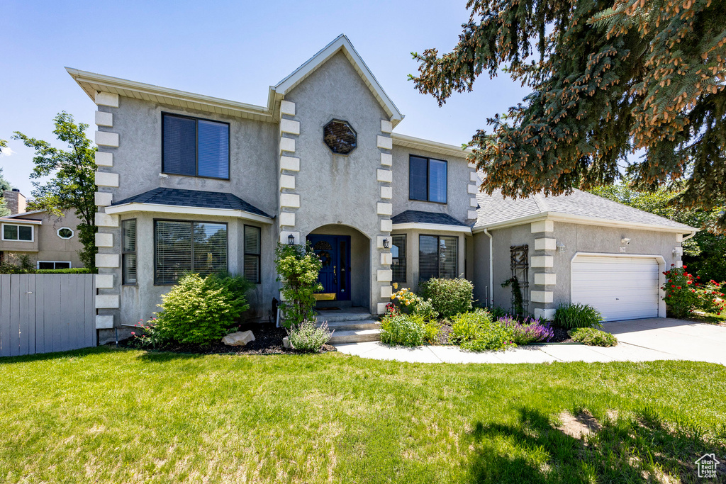 View of front of house with stucco siding, a garage, and driveway