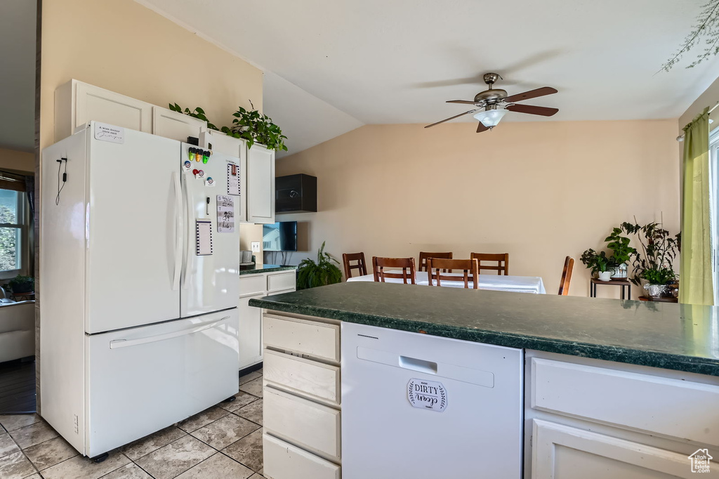Kitchen featuring white appliances, ceiling fan, white cabinetry, dark countertops, and vaulted ceiling
