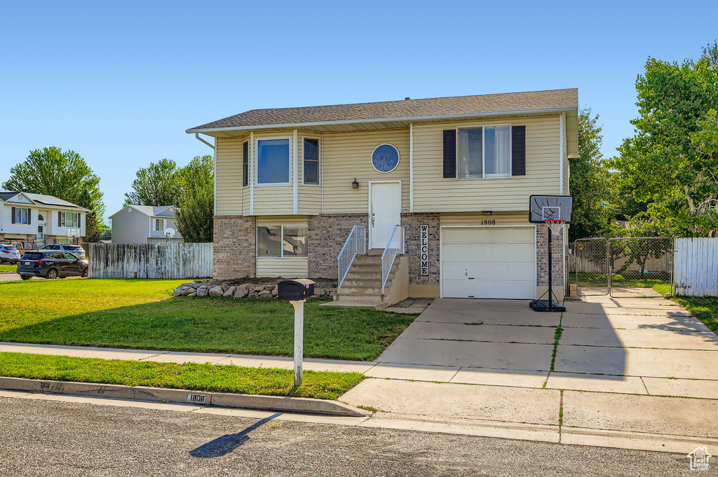 Split foyer home featuring brick siding, driveway, and a garage