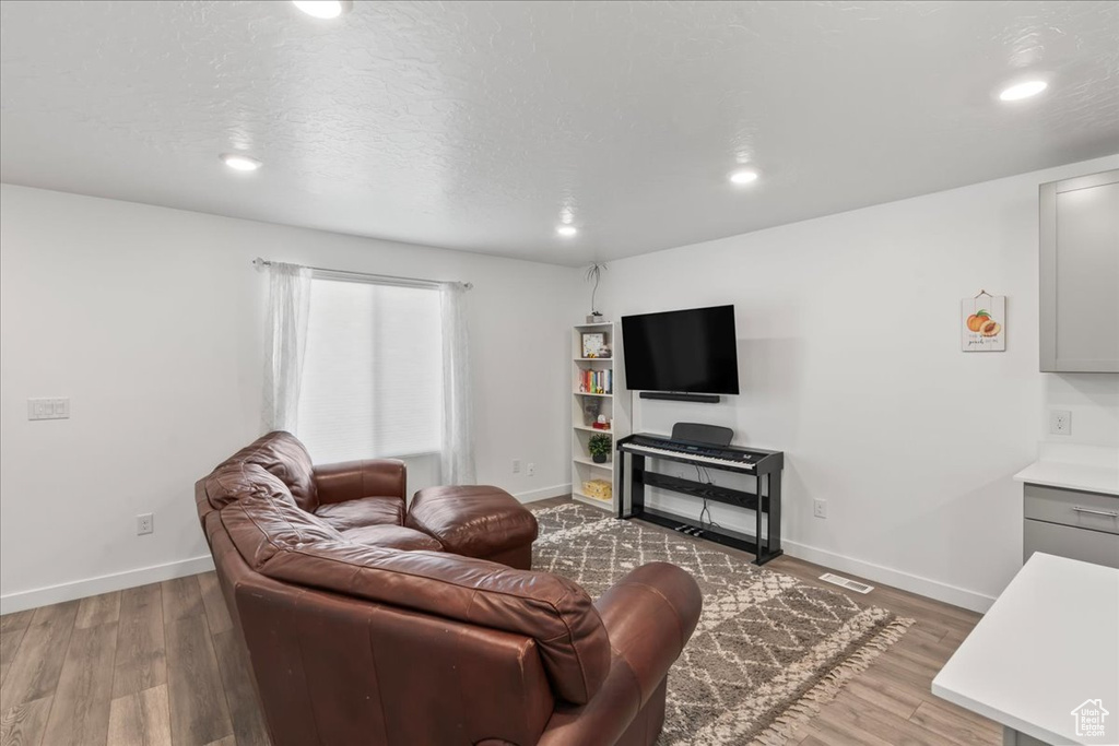 Living area featuring wood finished floors and recessed lighting
