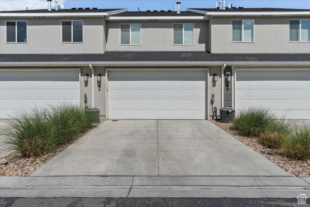 View of front of house featuring stucco siding, concrete driveway, and an attached garage