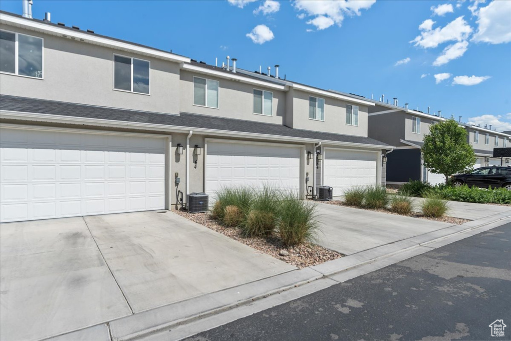 Traditional home with stucco siding, a garage, and concrete driveway
