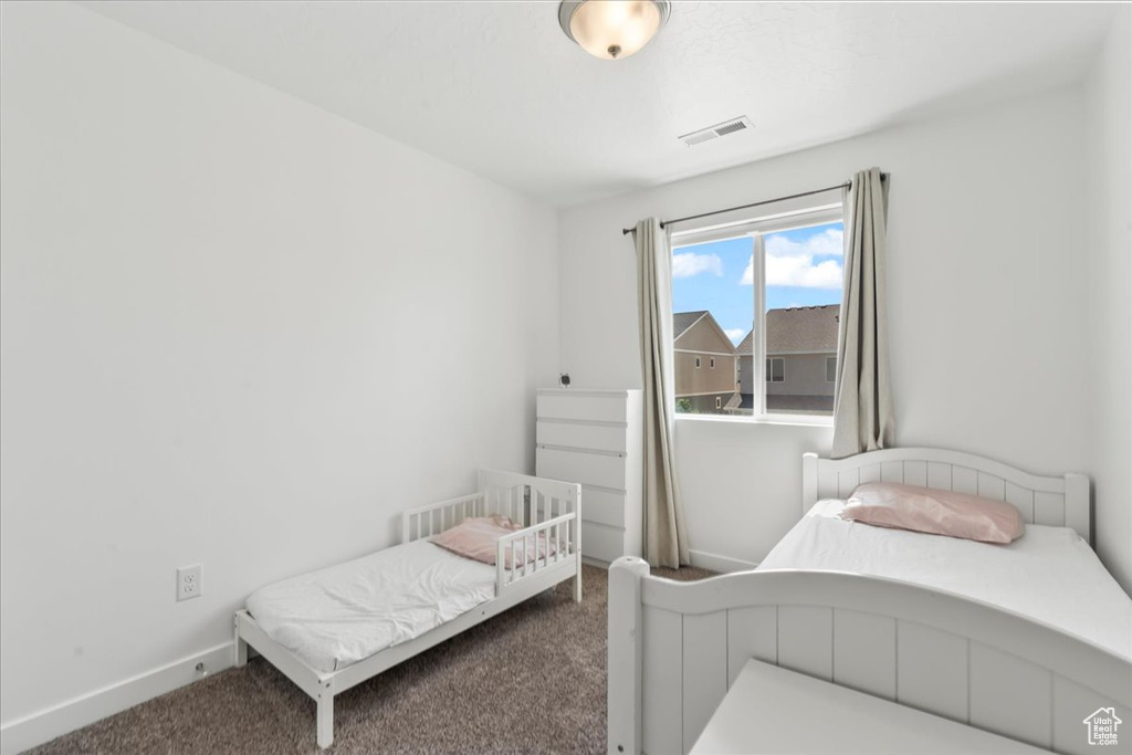 Bedroom featuring carpet and baseboards