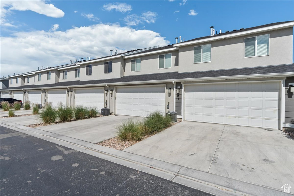 View of front facade featuring stucco siding, a garage, and concrete driveway