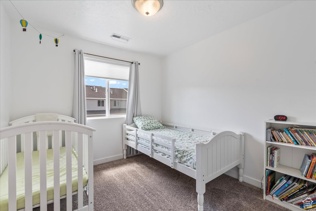 Bedroom featuring carpet and baseboards