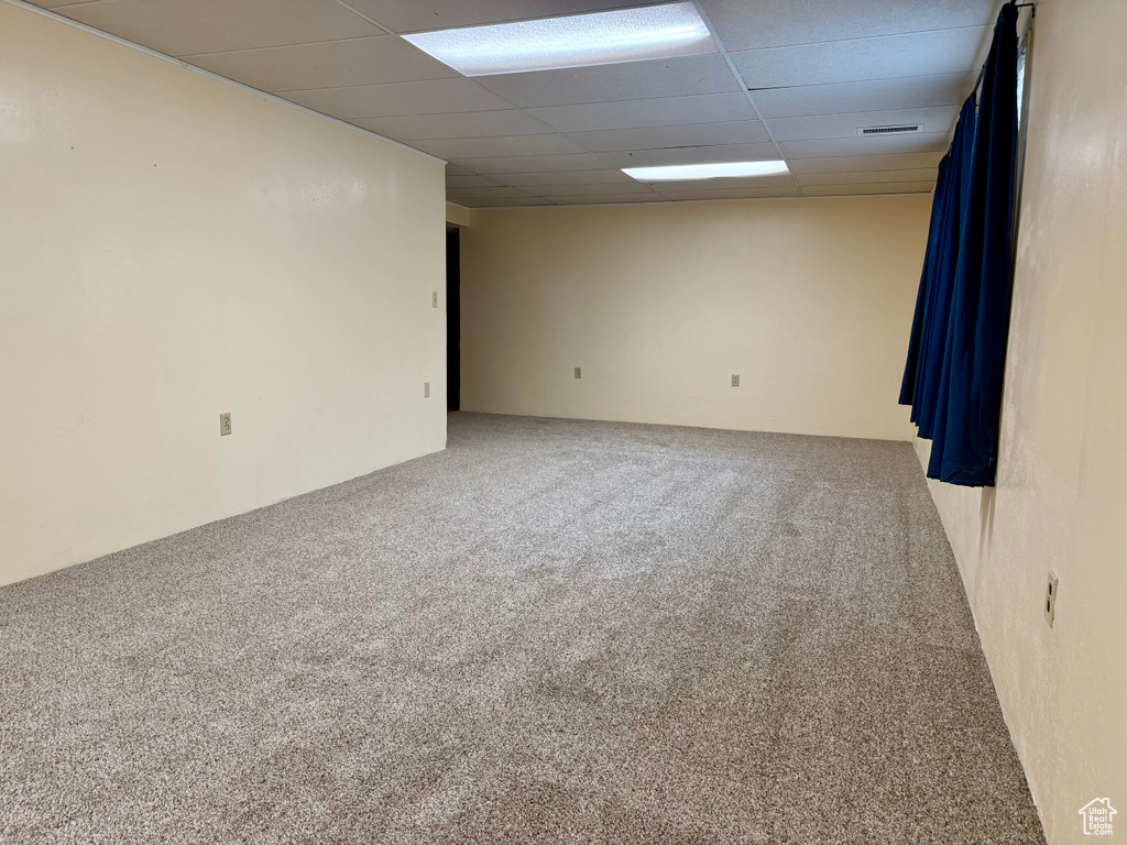Carpeted empty room featuring a paneled ceiling