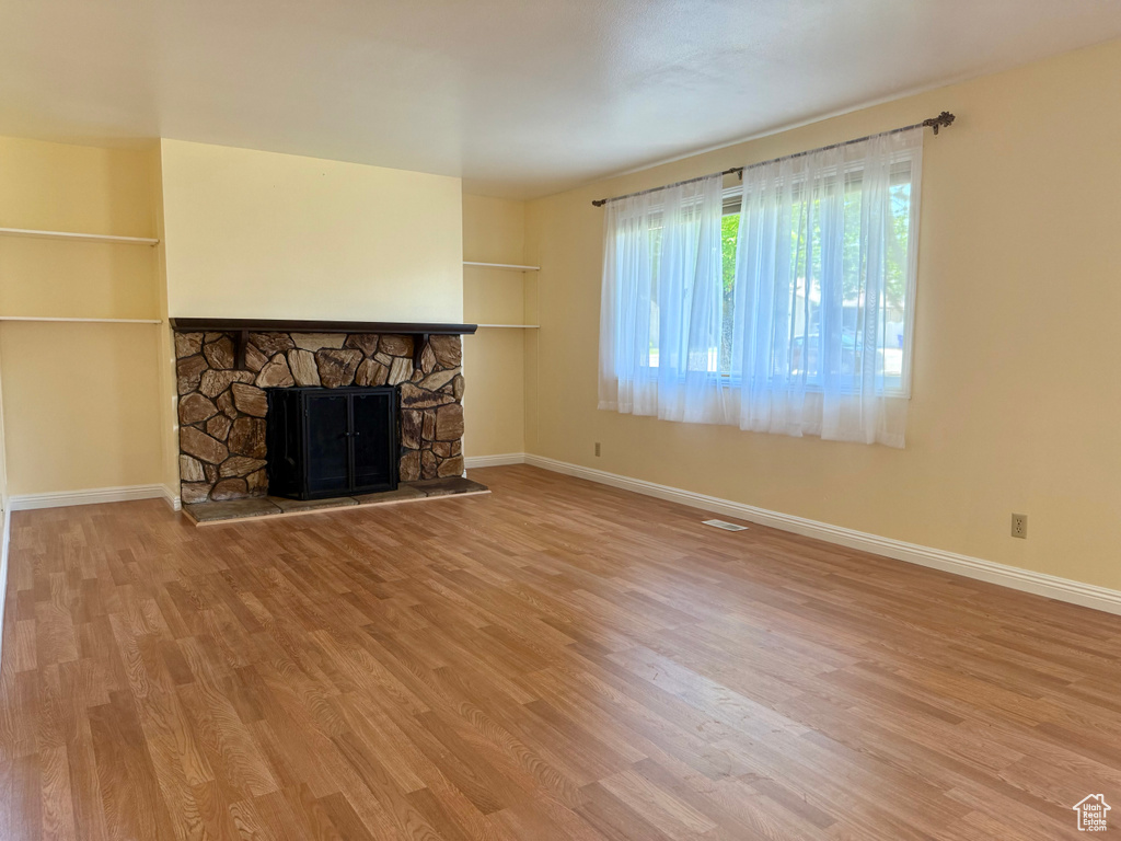 Unfurnished living room featuring wood finished floors and a fireplace