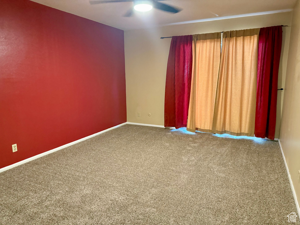 Unfurnished room with ceiling fan and carpet flooring