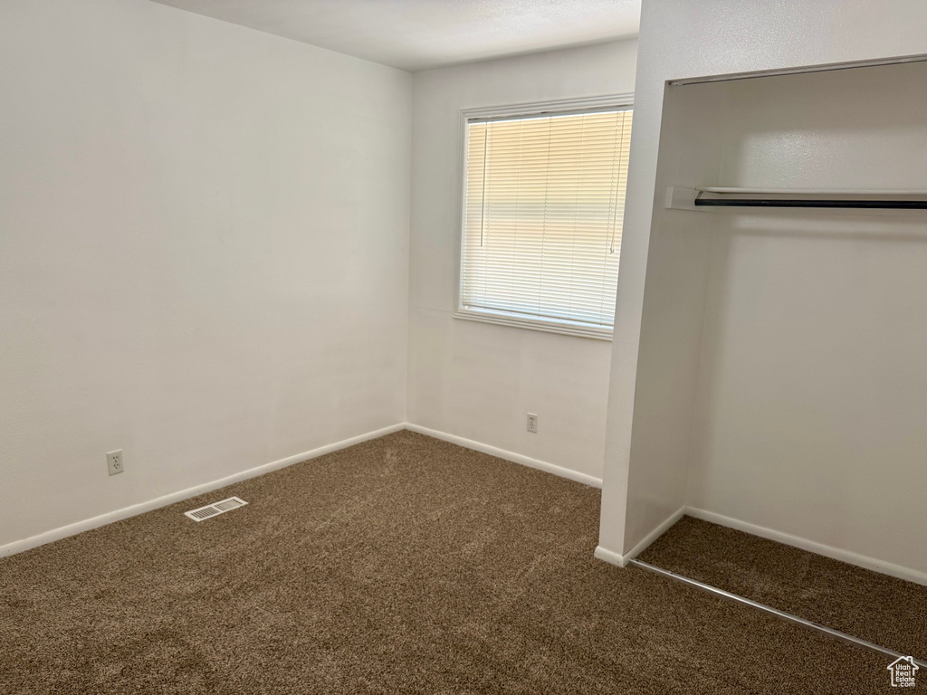 Unfurnished bedroom featuring carpet floors and baseboards