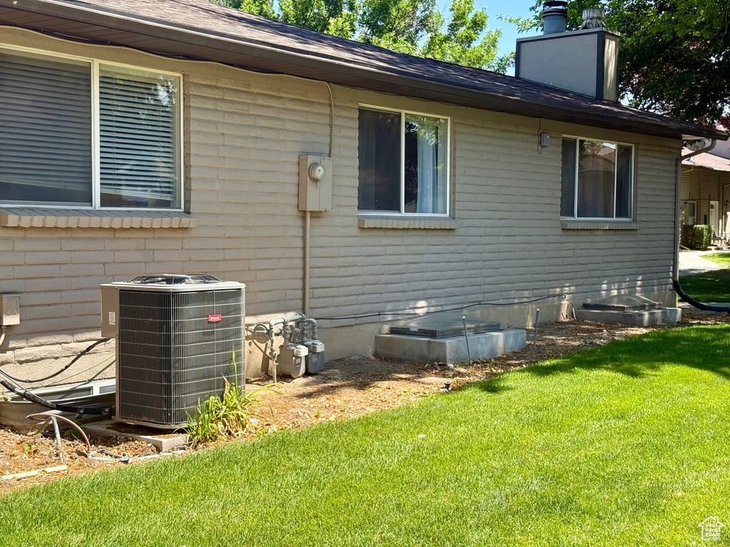 View of property exterior with a yard and a chimney