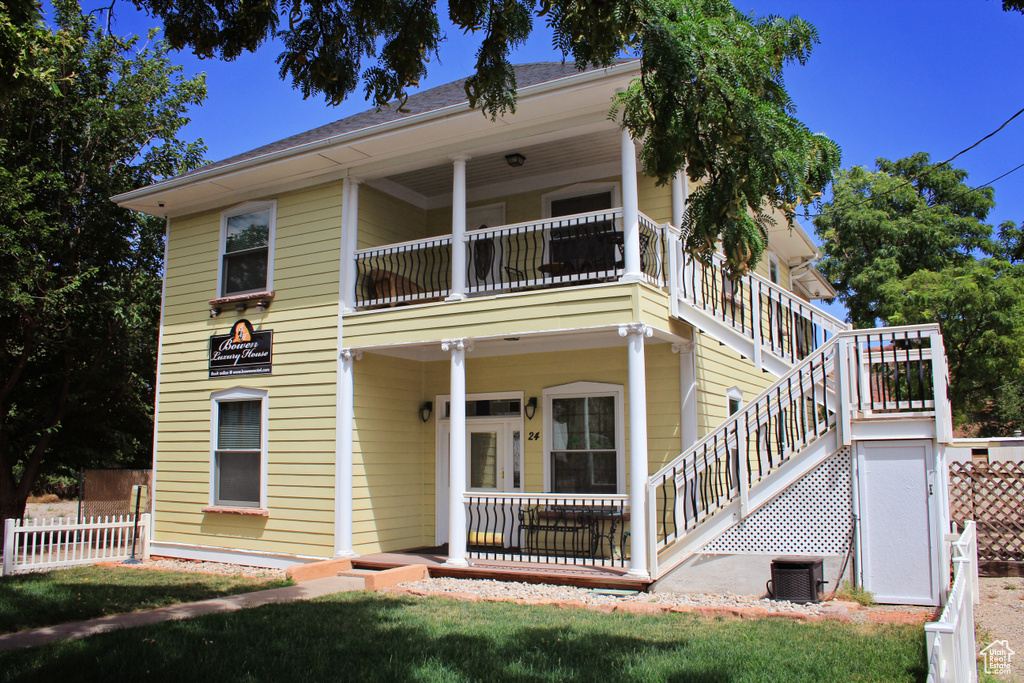 View of front of house with stairs and a balcony