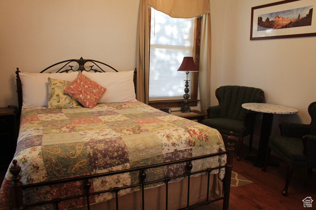 Bedroom featuring dark wood-style flooring and multiple windows