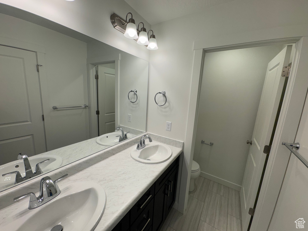 Bathroom with double vanity and tile patterned flooring